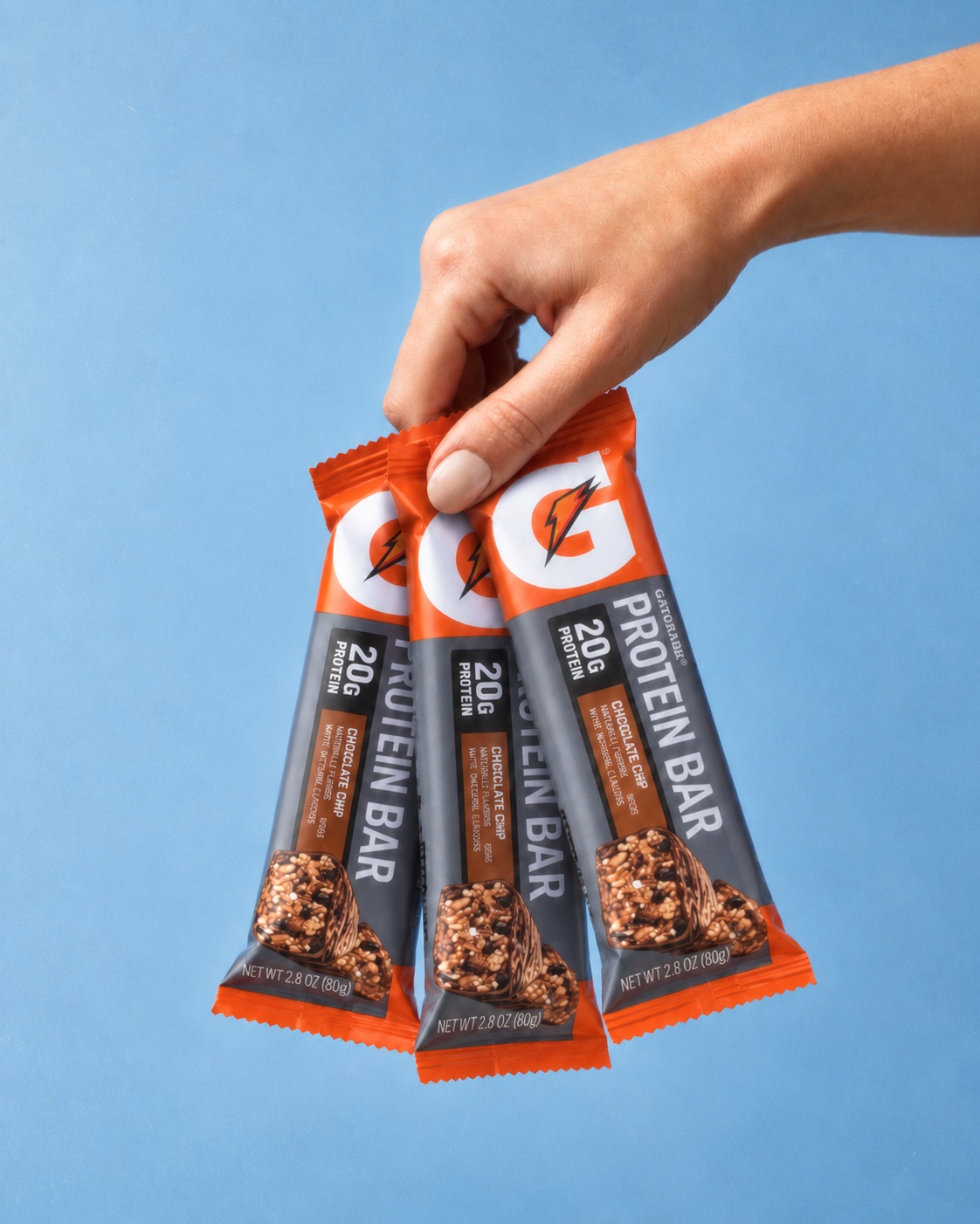 Mano sosteniendo 3 barras GATORADE Protein Bar sabor Chocolate Chip